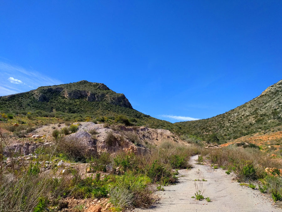 La senda sube por las instalaciones abandonadas de un solar 