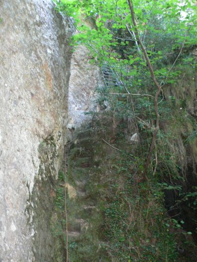 Primer resalte con una cuerda y una escalera tallada en la roca. Arriba vemos la escalera metálica 