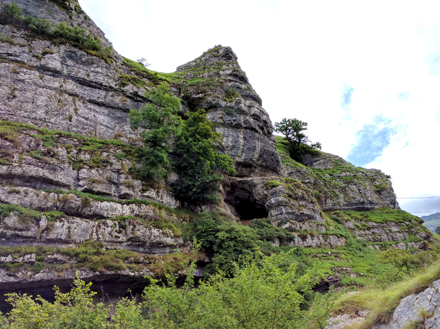 Cueva dónde descansan las cabras con un puente nepalí que la cruza 