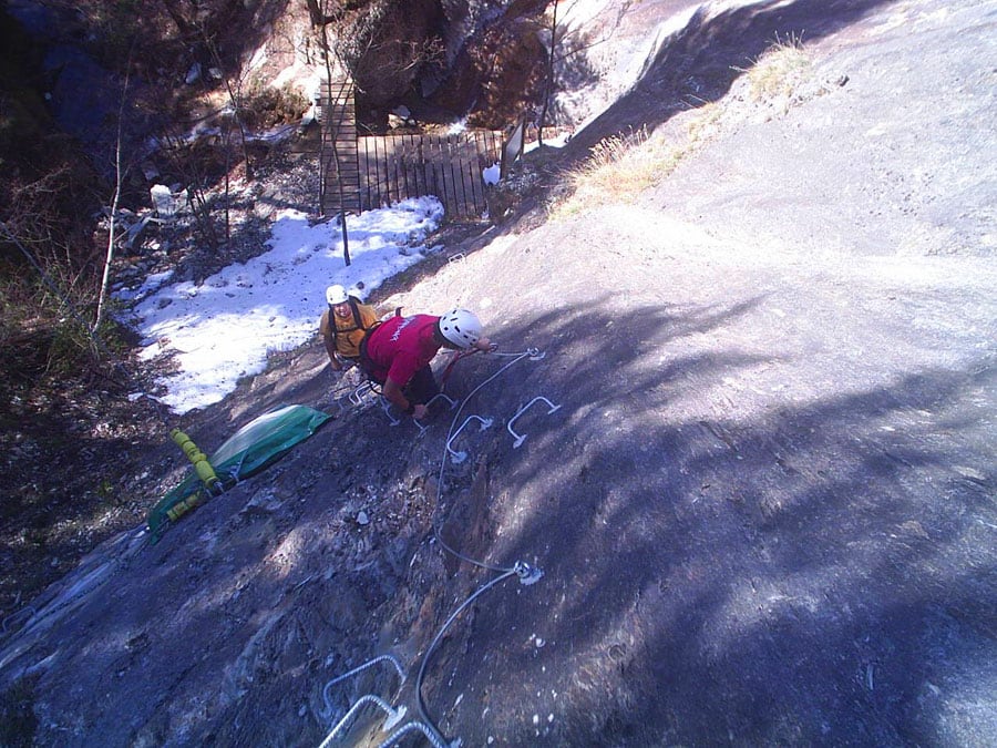 Inicio de la vía. Junto a la placa de nieve podemos ver la plataforma de madera encima del barranco y en la pared la colchoneta de protección para la última tirolina del bosque de aventura 