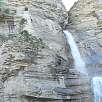 La cascada baja con fuerza en época de deshielo. Al costado se puede ver gente accediendo a la cueva / Cascada del Sorrosal 